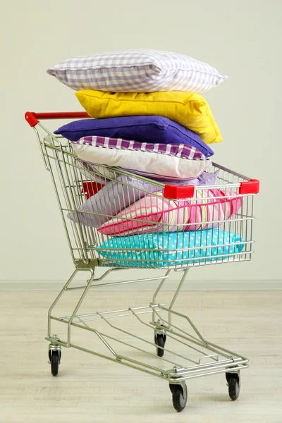 Shopping cart with pillows, on gray background — Stock Photo, Image