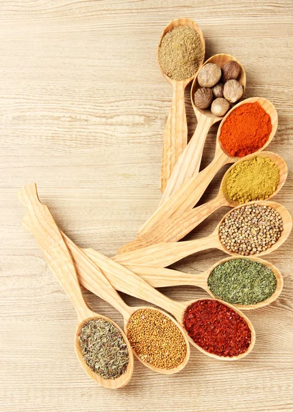 Assortment of spices in wooden spoons on wooden background — Stock Photo, Image