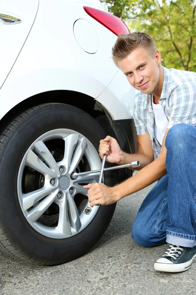 Man driver having trouble at road changing wheel — Stock Photo, Image