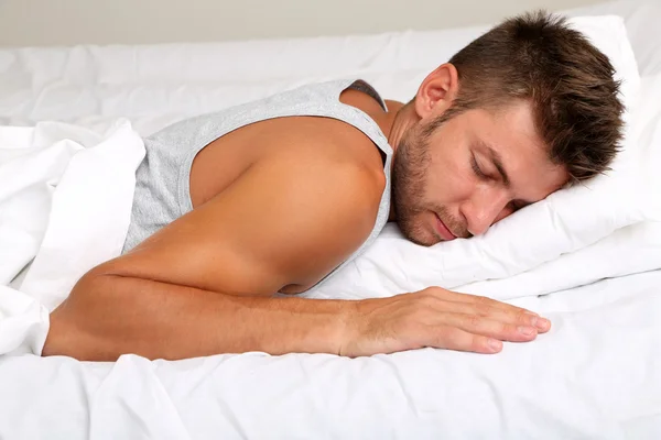 Schöner junger Mann im Bett — Stockfoto