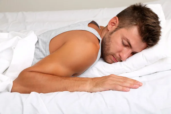 Bonito jovem homem na cama — Fotografia de Stock