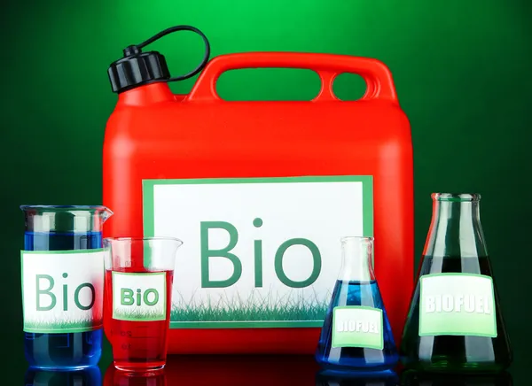 Bio fuels in canister and vials on green background — Stock Photo, Image