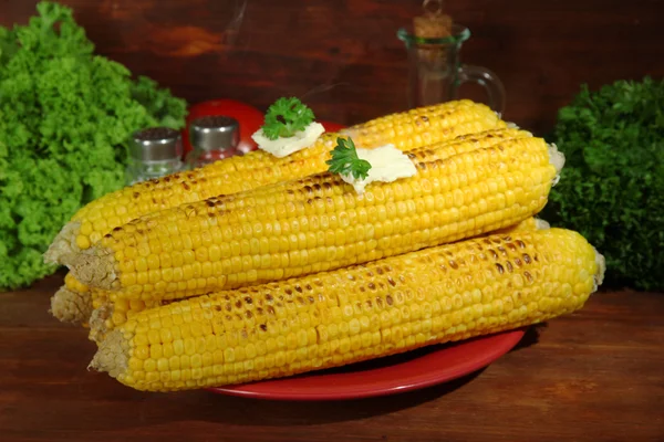 Delicioso maíz dorado a la parrilla con mantequilla en la mesa sobre fondo de madera —  Fotos de Stock