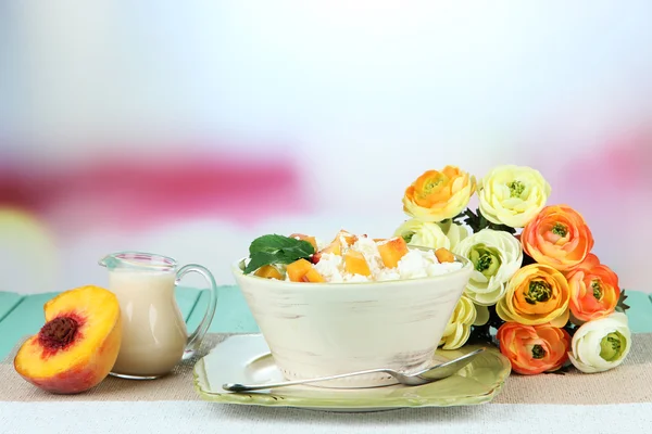 Sour cheese and pieces of fresh peach,on wooden table, on light background