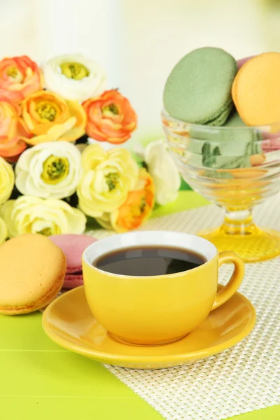 Kaffee und Makronen auf dem Tisch vor hellem Hintergrund — Stockfoto