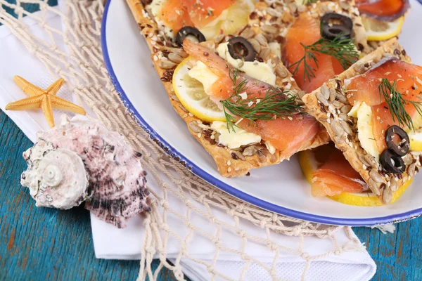 Zalm broodjes op plaat op houten tafel close-up — Stockfoto