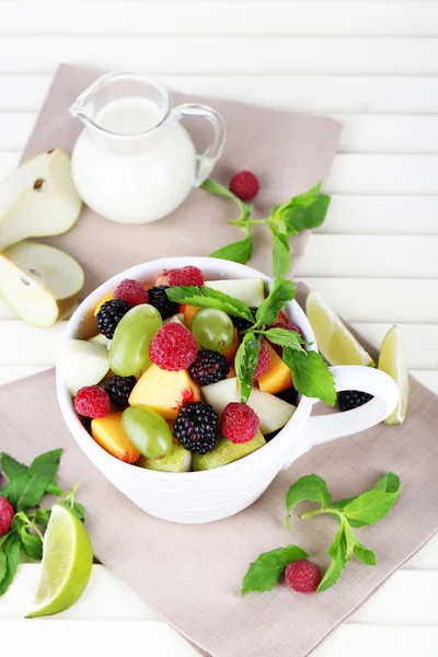 Fruit salad in cup on wooden table — Stock Photo, Image