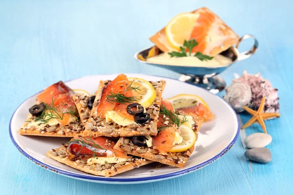 Zalm broodjes op plaat op houten tafel close-up — Stockfoto