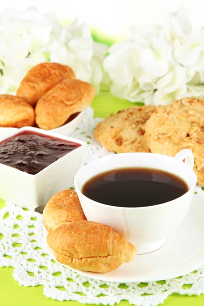 Tasty croissants and cup of coffee on table close-up — Stock Photo, Image