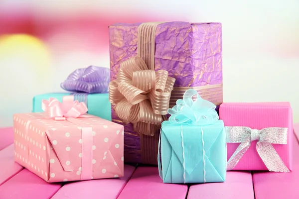 Hermosos regalos brillantes, sobre mesa de madera brillante — Foto de Stock