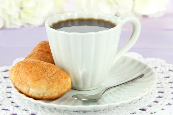 Tasty croissants and cup of coffee on table close-up — Stock Photo, Image