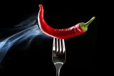 siyah üzerine izole çatal üzerinde kırmızı sıcak biber biber