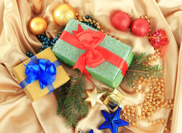 Όμορφα φωτεινά δώρα και διακόσμηση Χριστούγεννα, σε μεταξωτό ύφασμα — Φωτογραφία Αρχείου