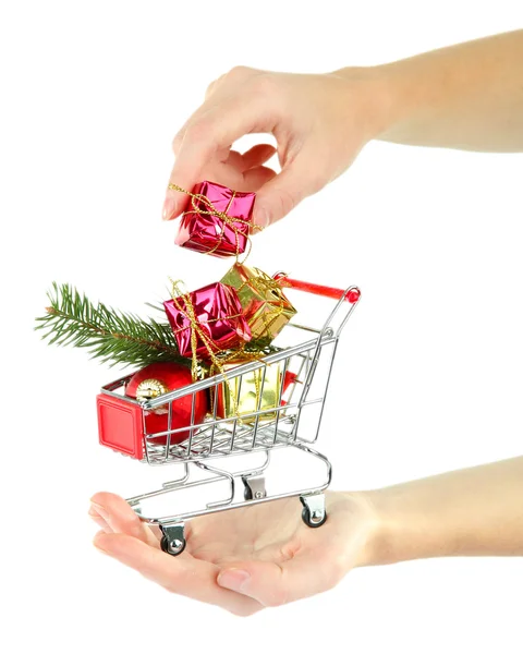 Mão segurando presentes de Natal no carrinho de compras, isolado em branco — Fotografia de Stock