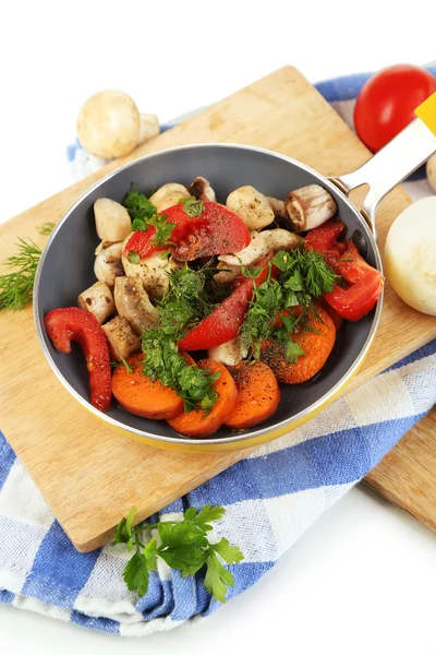 Verduras frescas en rodajas en sartén sobre tabla de madera aislada sobre blanco — Foto de Stock