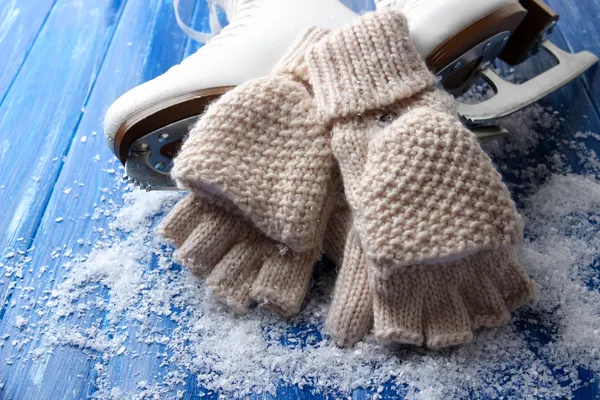 Fingerlose Handschuhe und Schlittschuhe aus Wolle für Eiskunstlauf, auf Holzgrund — Stockfoto