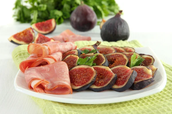 Smakelijke vijgen met ham op witte houten tafel — Stockfoto