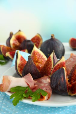 Tasty figs with ham on plate