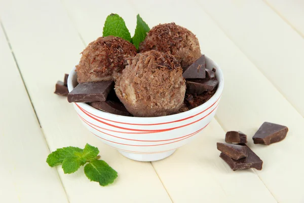 Tasty ice cream scoops in bowl, on wooden table — Stock Photo, Image