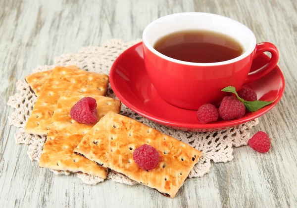 Xícara de chá com biscoitos e framboesas na mesa close-up — Fotografia de Stock