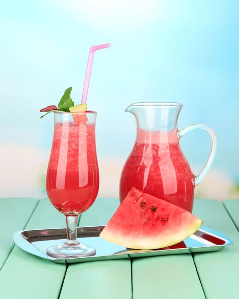 Glass of fresh watermelon juice, on tray, on wooden table, on bright background — Stock Photo, Image