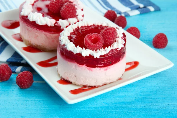 Delicious berry cakes on plate on table close-up