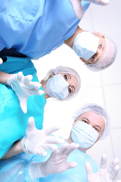 View from below of surgeons in protective work wear during operation — Stock Photo, Image