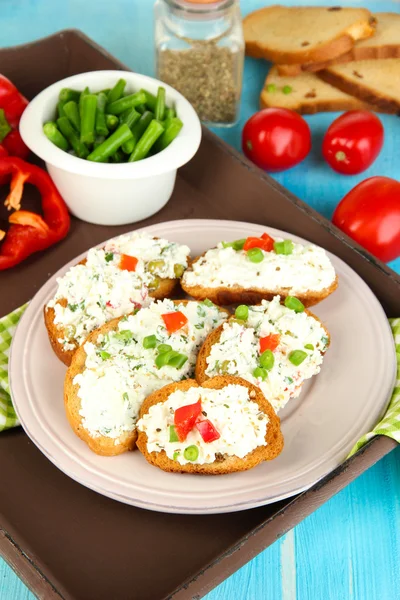 Sandwiches with cottage cheese and greens on plate on wooden table close-up — Stock Photo, Image
