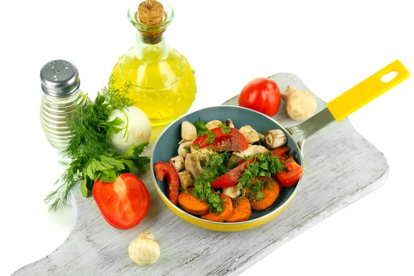 Verduras frescas en rodajas en sartén sobre tabla de madera aislada sobre blanco — Foto de Stock