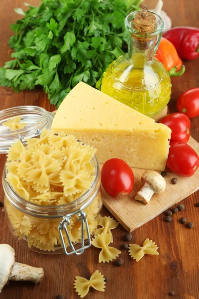 Pasta con aceite, queso y verduras en la mesa de madera de cerca —  Fotos de Stock