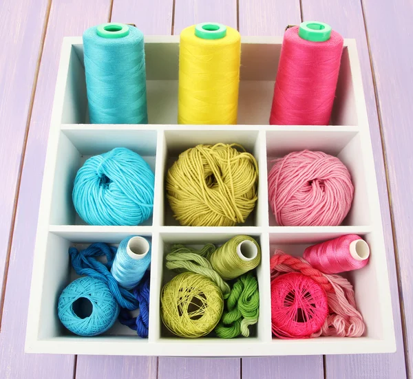 Multicolored skeins of thread in wooden box closeup — Stock Photo, Image