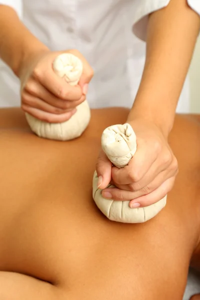 Pouches filled with dry herbs are brushed over body close up — Stock Photo, Image