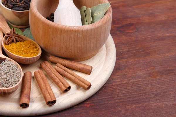 Verschillende kruiden en specerijen op houten tafel — Stockfoto