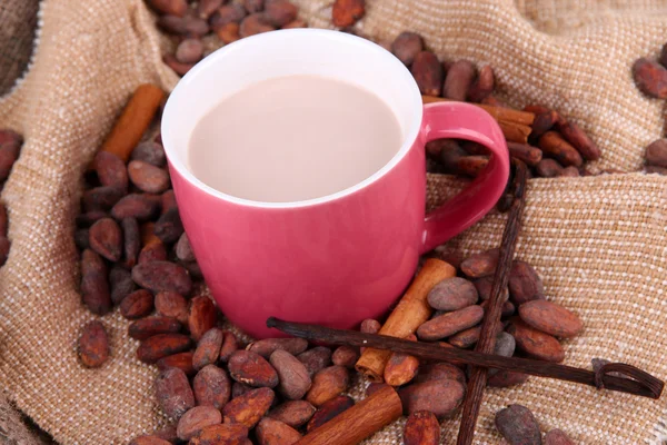 Cocoa drink and cocoa beans on sackcloth background — Stock Photo, Image