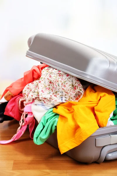 Suitcase with no neatly folded things on floor — Stock Photo, Image