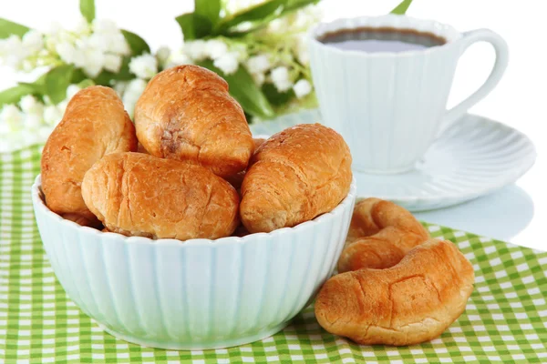 Croissants saborosos e xícara de café na mesa no fundo branco — Fotografia de Stock