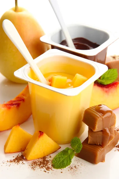 Összetétele a finom desszerteket, friss gyümölcsök és a karamell cukorkák, elszigetelt fehér — Stock Fotó