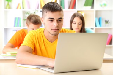 Kütüphanede oturan genç öğrenci grubu