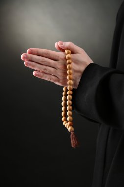 Tespih, siyah arka planda tutan rahip