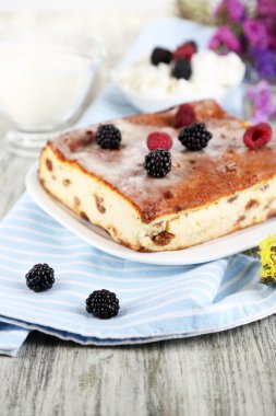 Ahşap masa yakın çekim peçeteye plaka üzerinde kuru üzüm ile peynir güveç