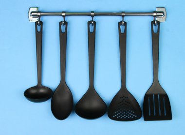 Gümüş kanca, mavi arka plan üzerinde siyah mutfak gereçleri