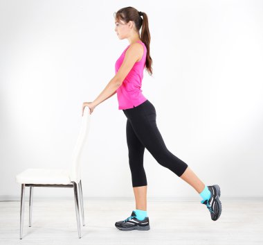 Güzel genç kız evde egzersiz yapıyor.