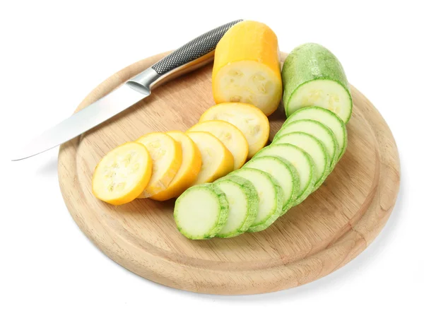 In Scheiben geschnittene und ganze rohe Zucchini auf Holzschneidebrett, isoliert auf weiß — Stockfoto