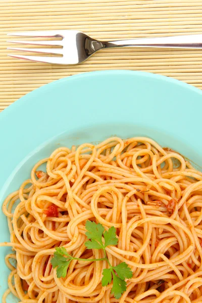 Italienische Spaghetti im Teller auf Bambusmatte in Großaufnahme — Stockfoto