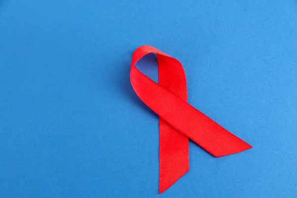Kırmızı kurdele HIV, AIDS üzerinde mavi arka plan — Stok fotoğraf