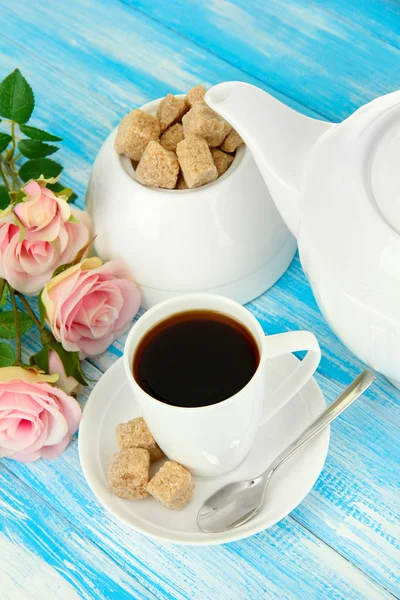 Tasse Kaffee, Teekanne und Zuckerdose auf farbigem Holzhintergrund — Stockfoto