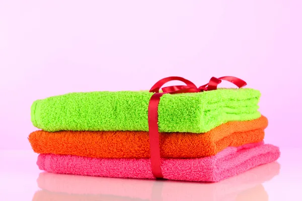 Handtücher mit Band auf hellrosa Hintergrund gebunden — Stockfoto
