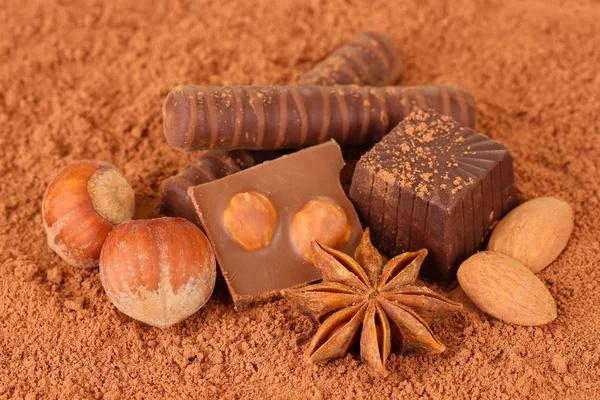 Chocolate sweets with cocoa, on brown background — Stock Photo, Image