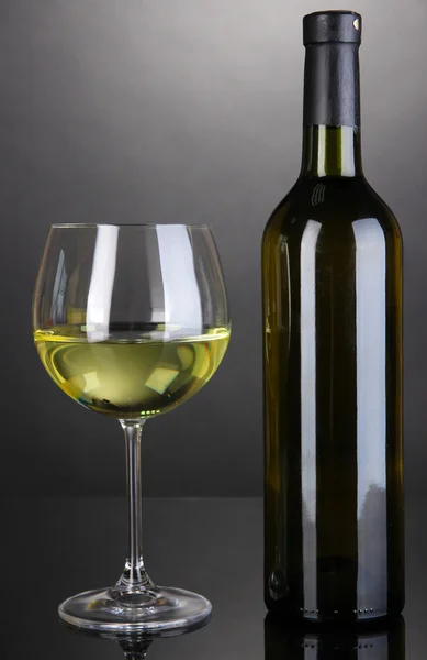Beyaz Şarap kadehi ve gri arka plan üzerinde şarap şişe — Stok fotoğraf