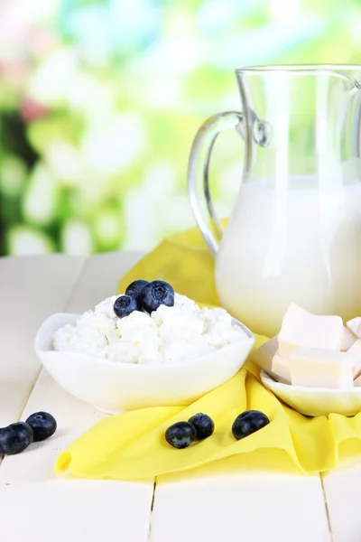 Свежие молочные продукты с черникой на деревянном столе на естественном фоне — стоковое фото